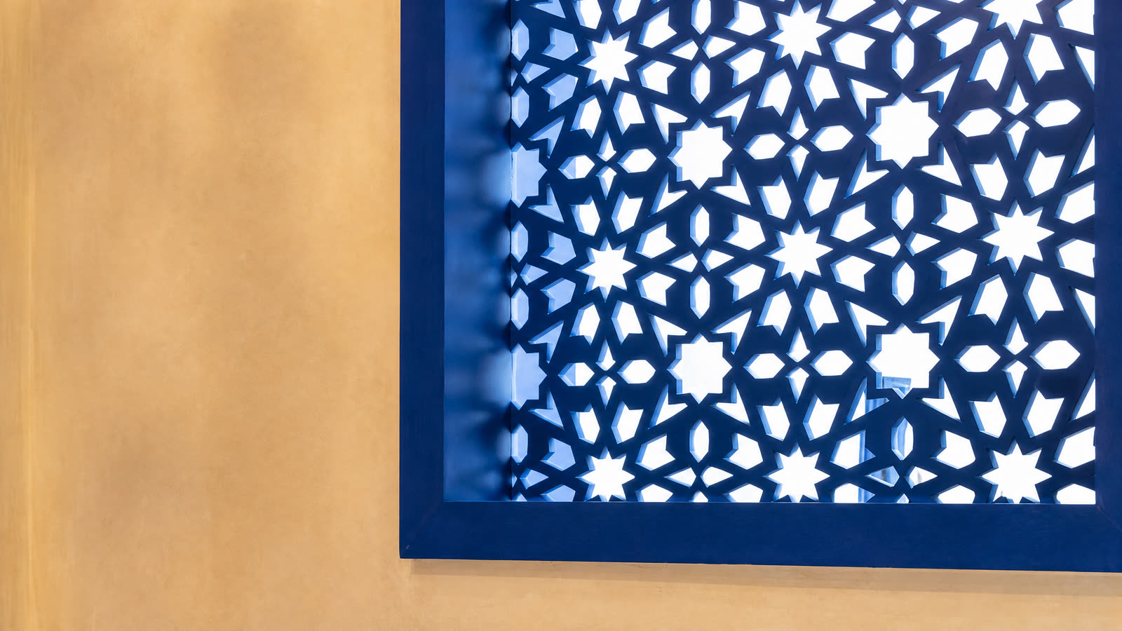 Un moucharabieh bleu qui filtre la lumière en étoiles.