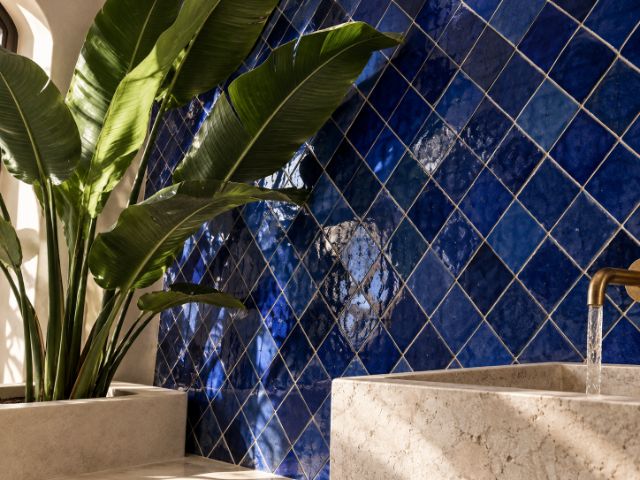 Blue zellige laid on the diagonal above a stone basin