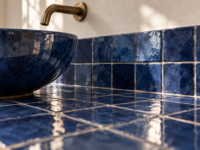 Glazed blue basin on a cobalt zellige counter