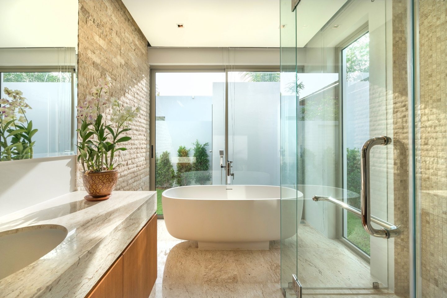 Light stone bathroom with a glass shower