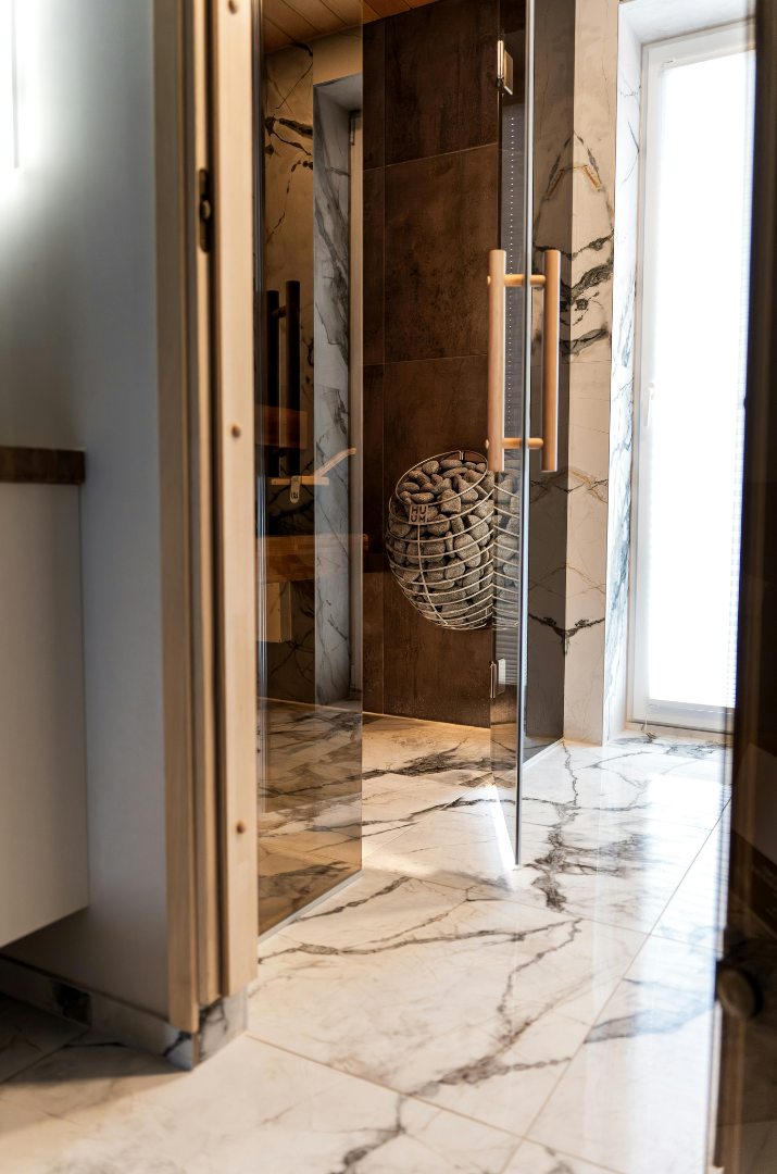 Salle de bain au plancher de marbre vue à travers une porte vitrée