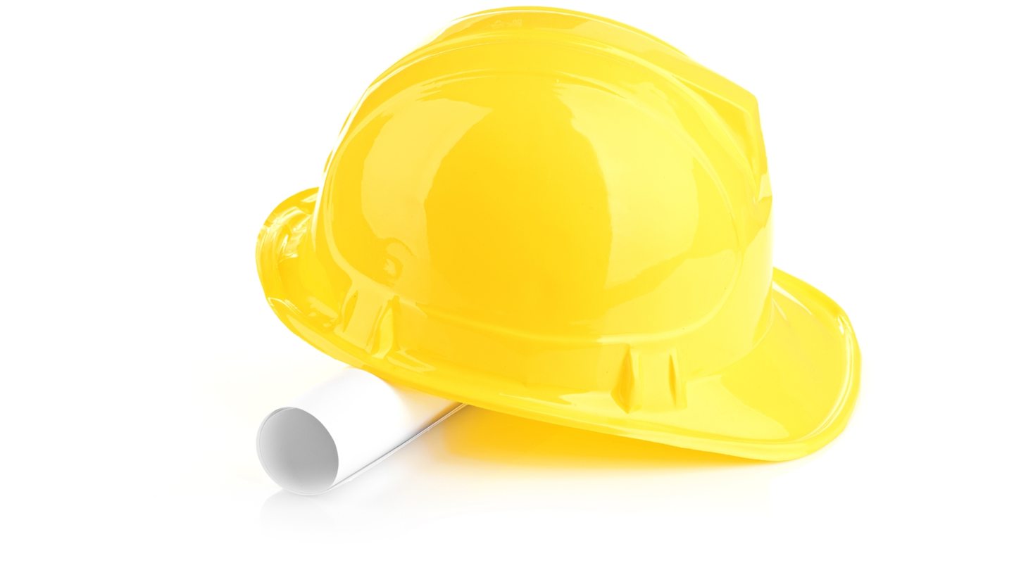 Casque de chantier jaune et plans roulés
