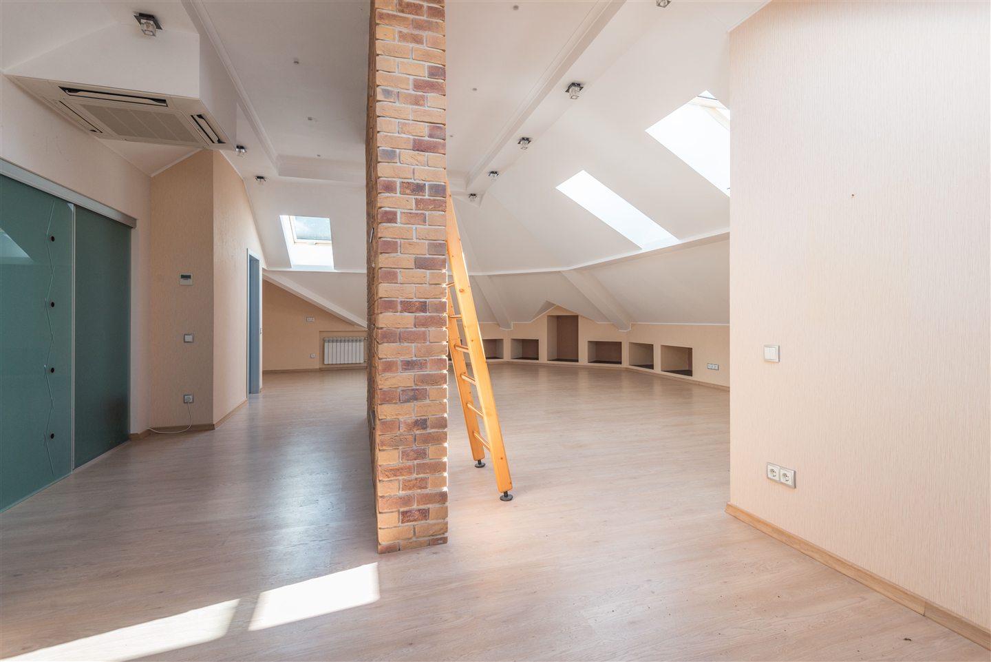 Large unfinished attic space with skylights and a brick column