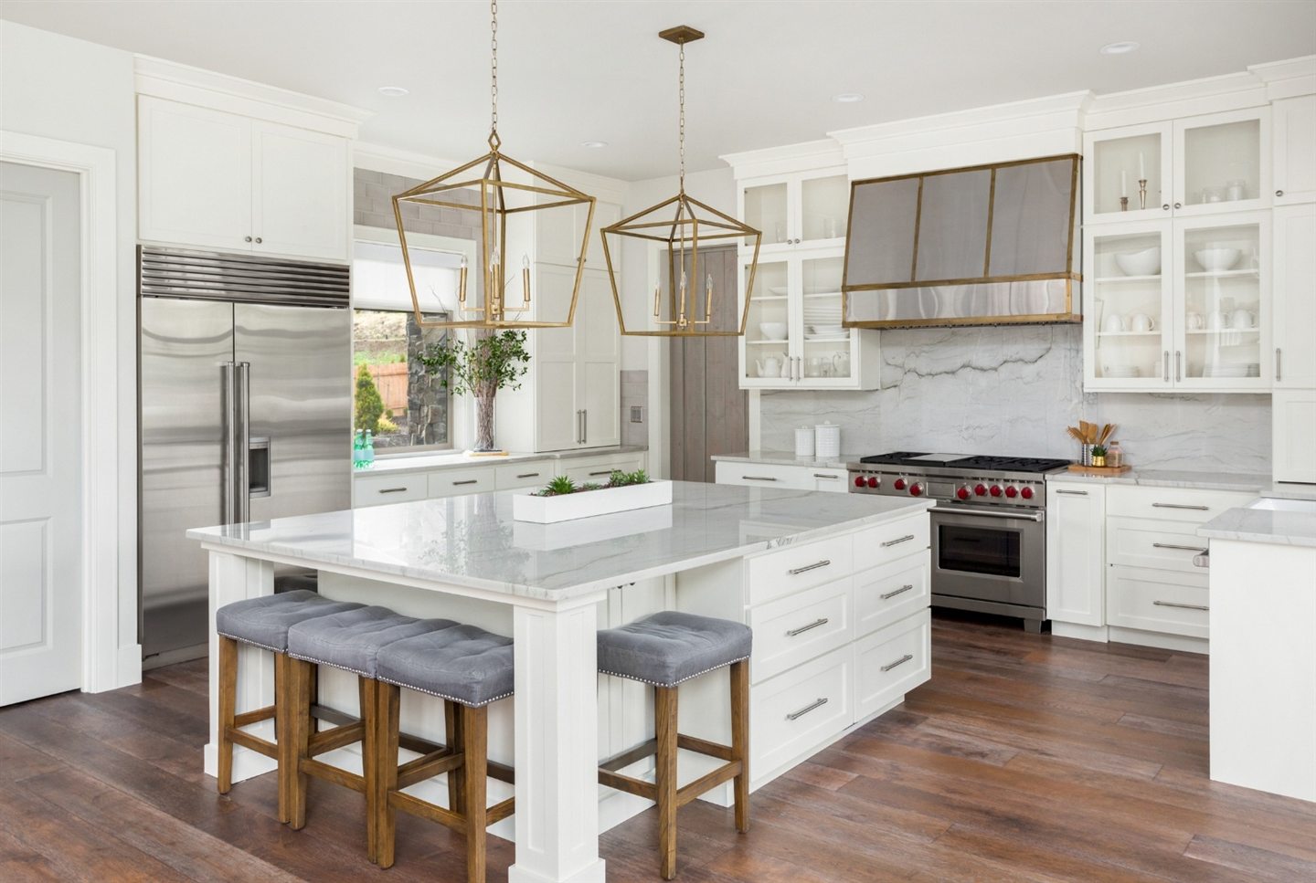White kitchen with pendant lights and stools