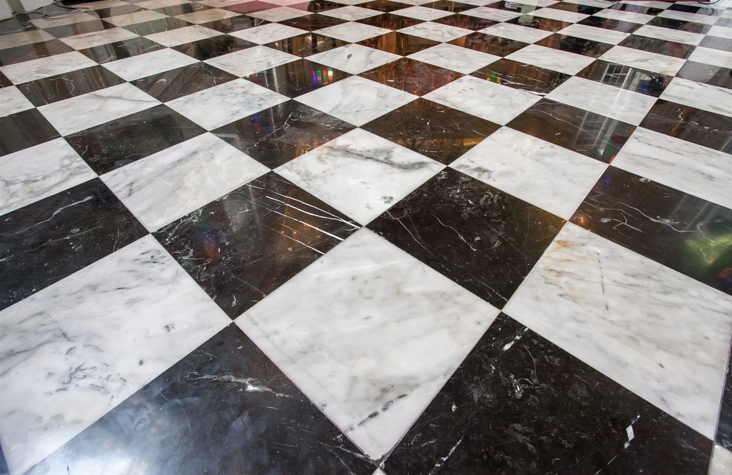 Plancher de marbre en damier noir et blanc, posé en diagonale