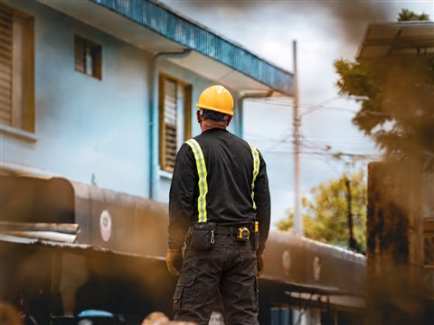 Membre de l’équipe devant une façade en rénovation