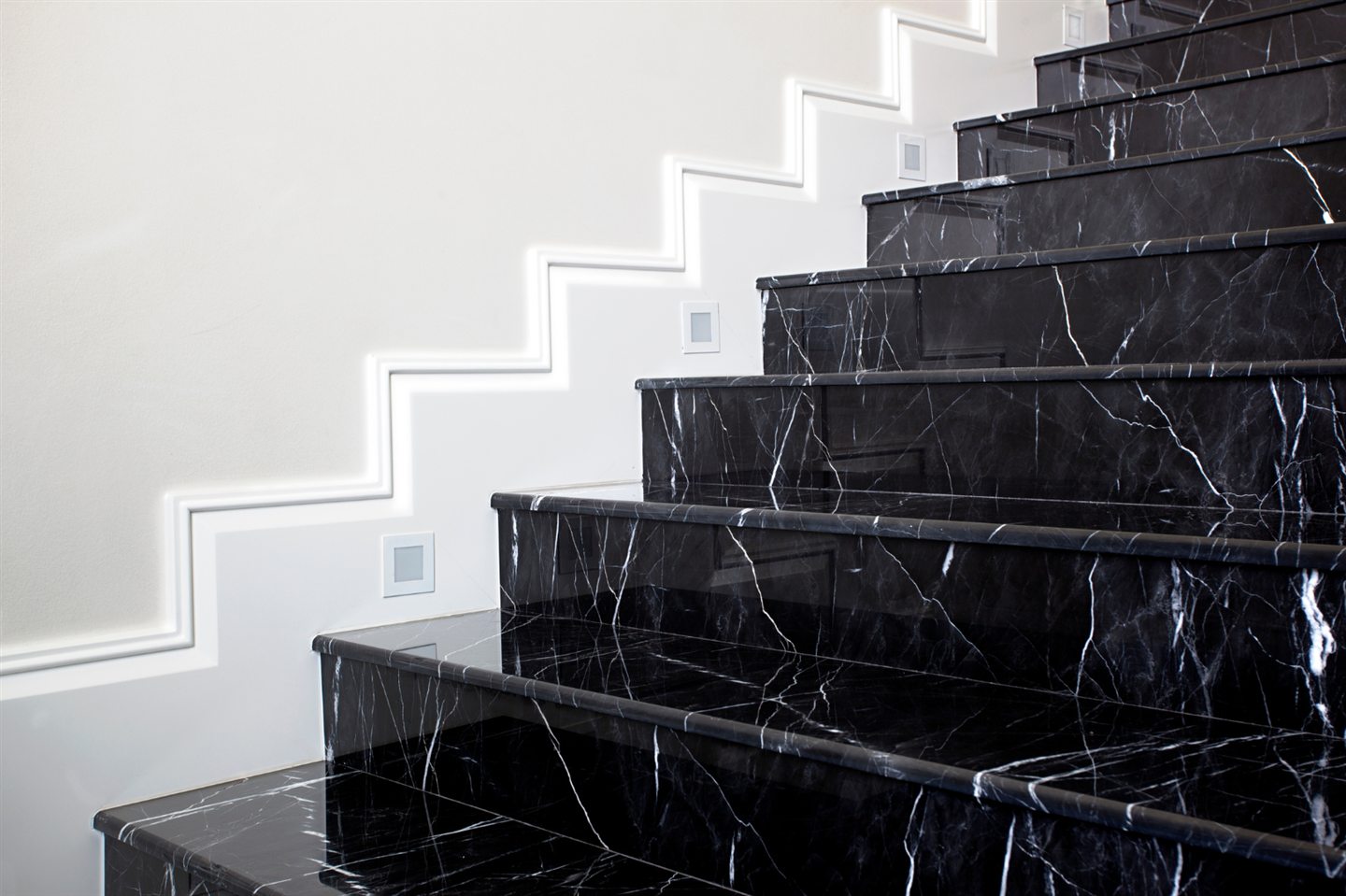 Escalier de marbre noir contre un mur blanc