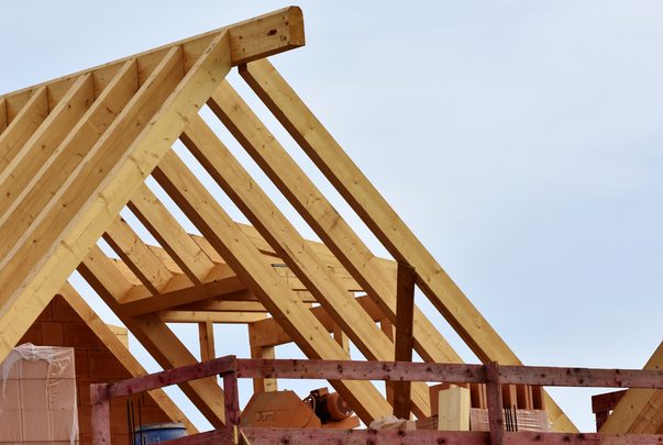 Wooden roof trusses against a blue sky