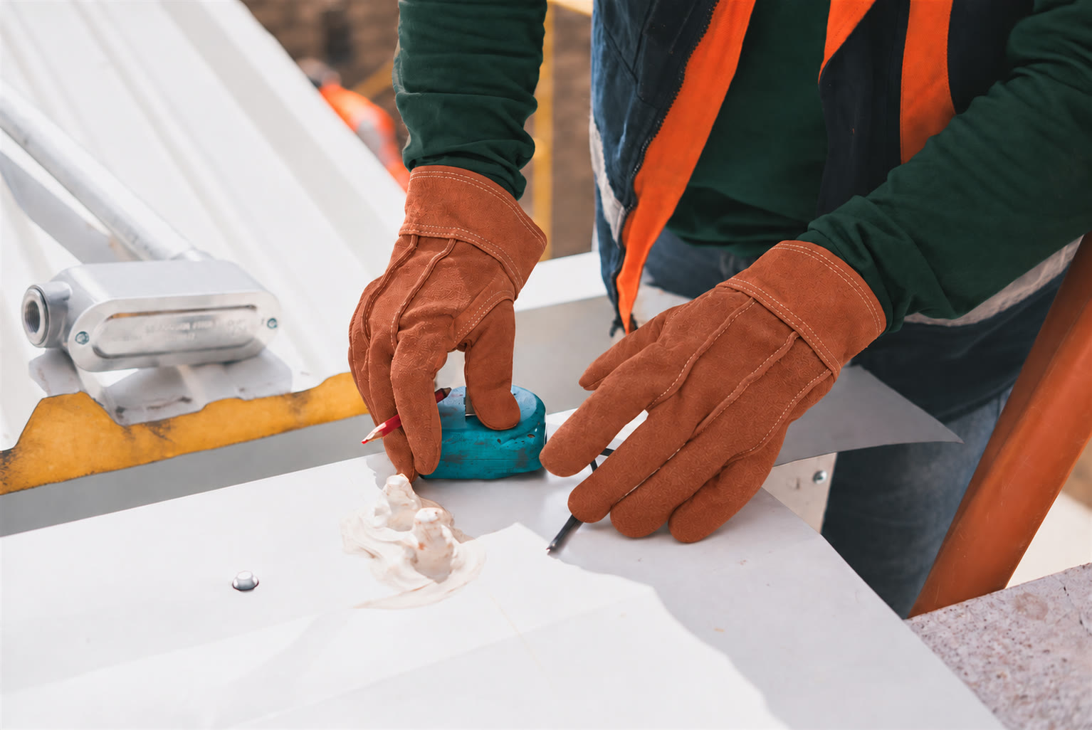 Gloved hands mark a precise cut on a panel.