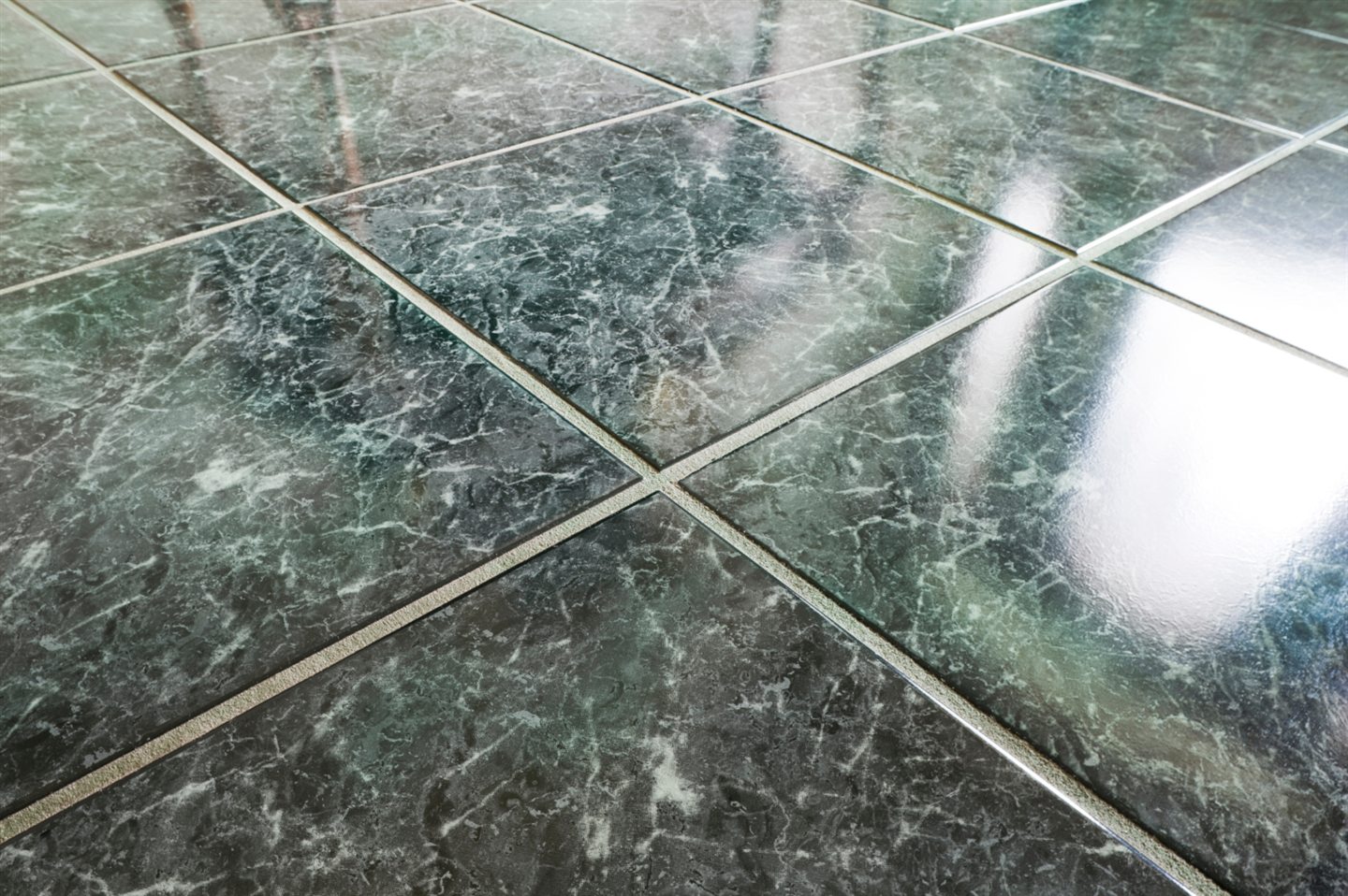 Carreaux de marbre vert poli posés en diagonale