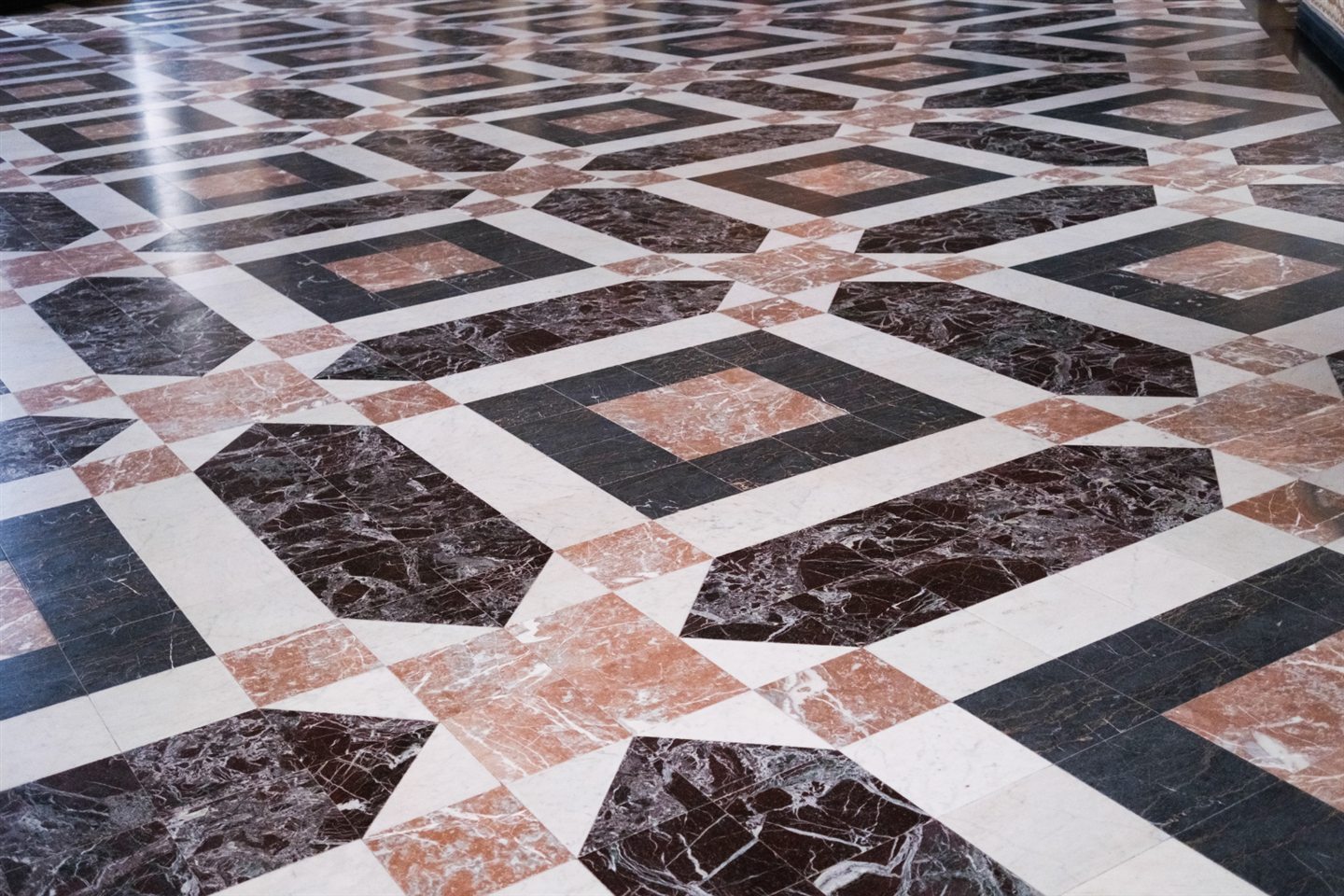 Plancher de marbre en marqueterie : noir, bordeaux, rose et blanc