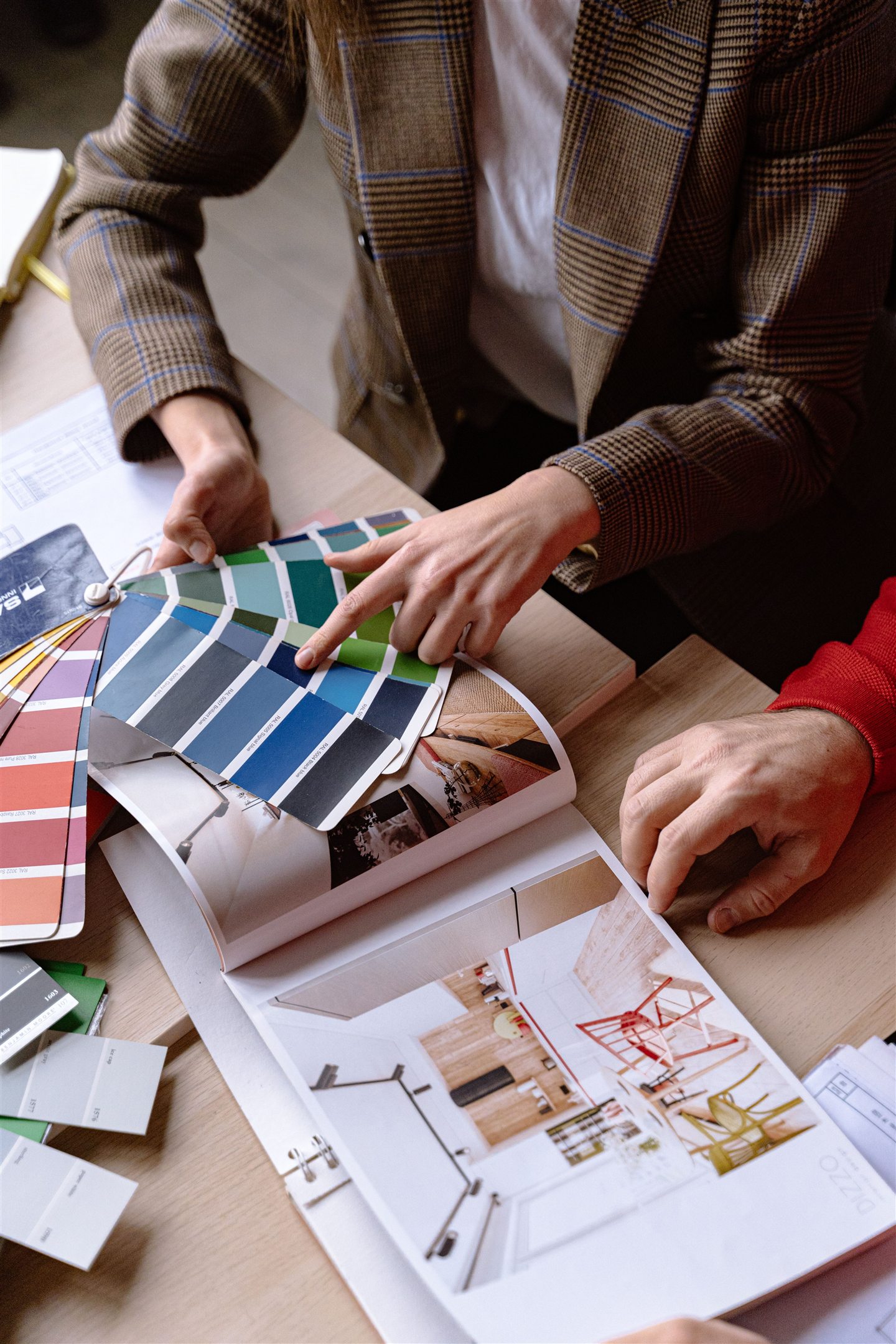 Mains comparant un nuancier de couleurs sur un plan