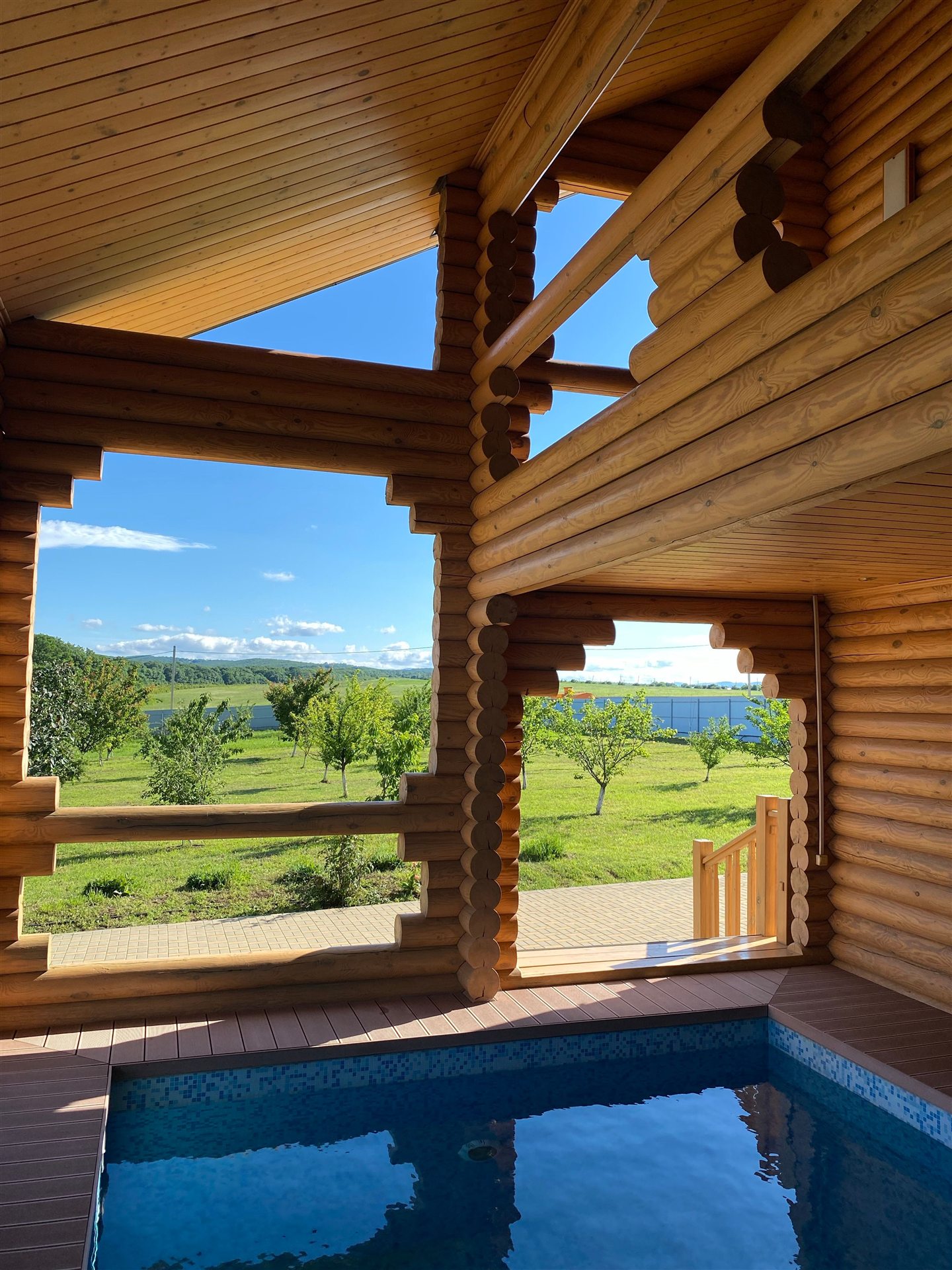 Vue sur le jardin à travers les ouvertures d’un pavillon en bois