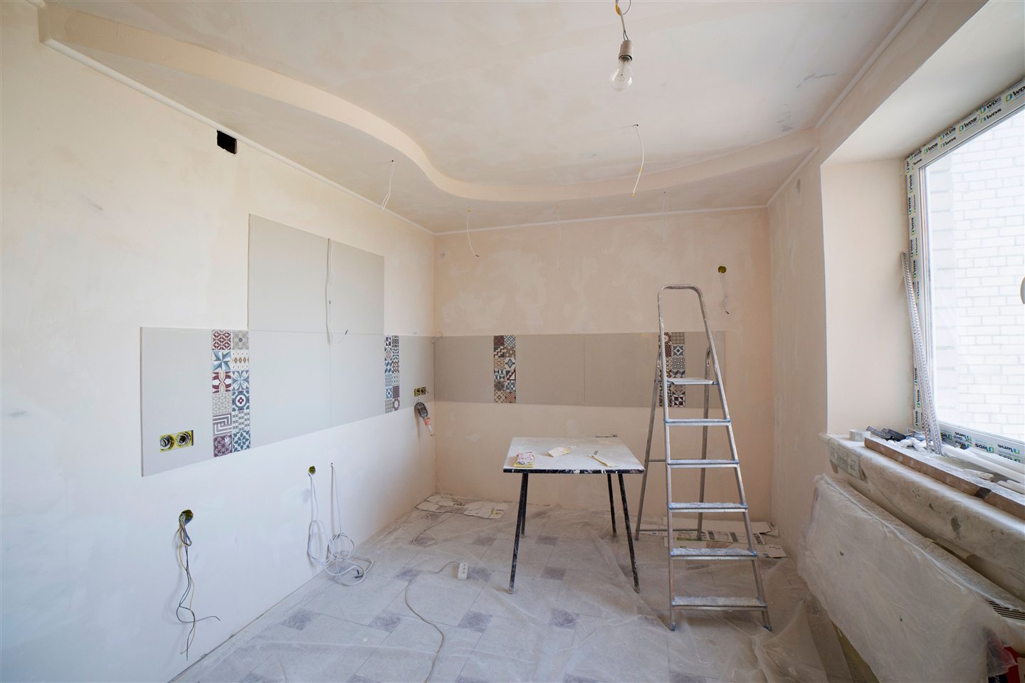 Pièce vide en préparation, murs apprêtés et escabeau