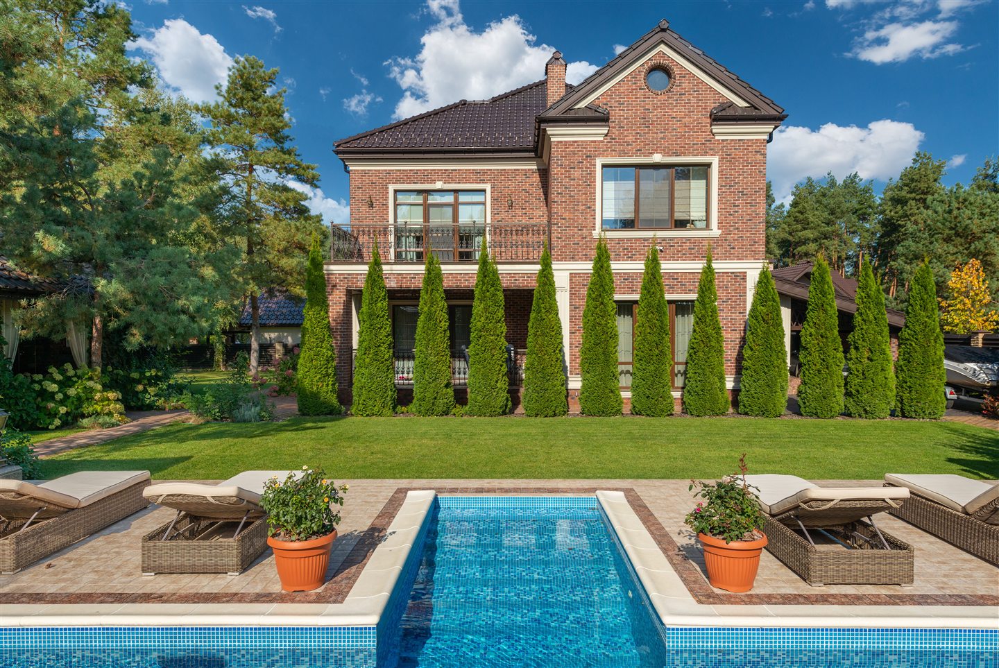 Piscine devant une maison en brique
