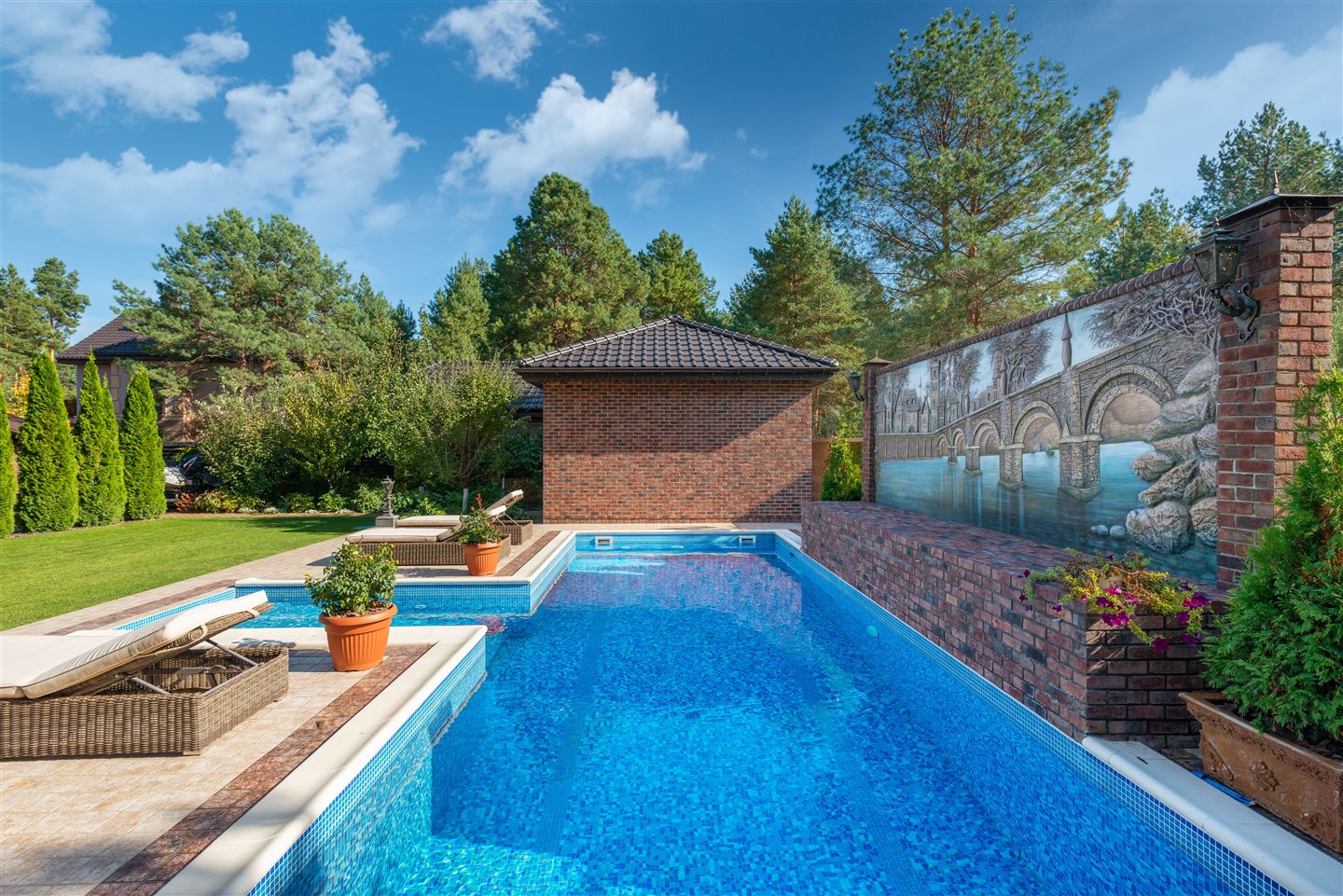 Piscine creusée rectangulaire en mosaïque bleue, avec pool house