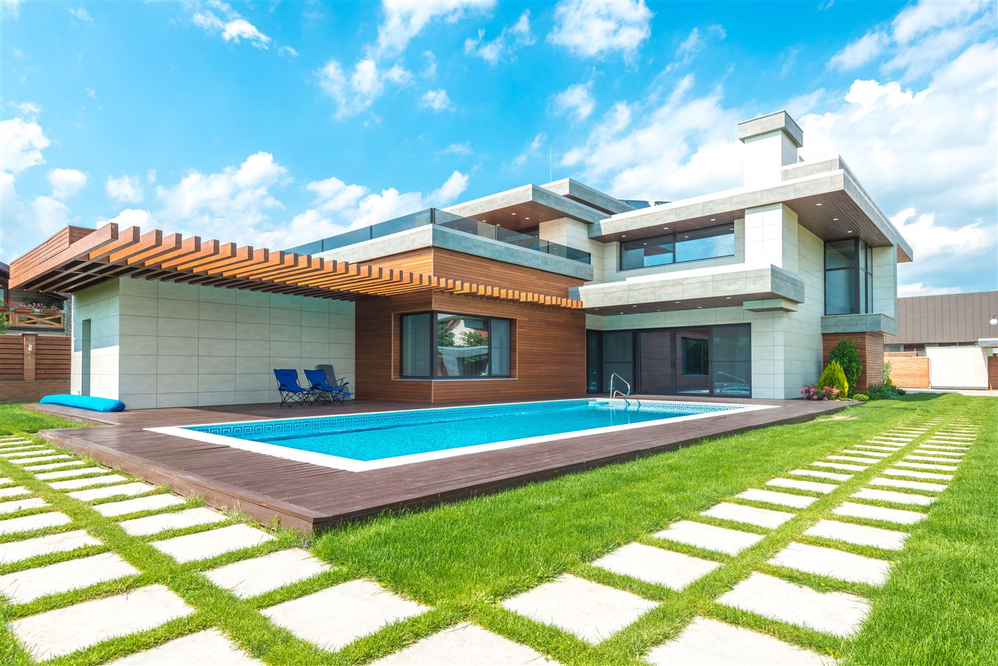 Maison moderne avec piscine creusée et dalles dans la pelouse