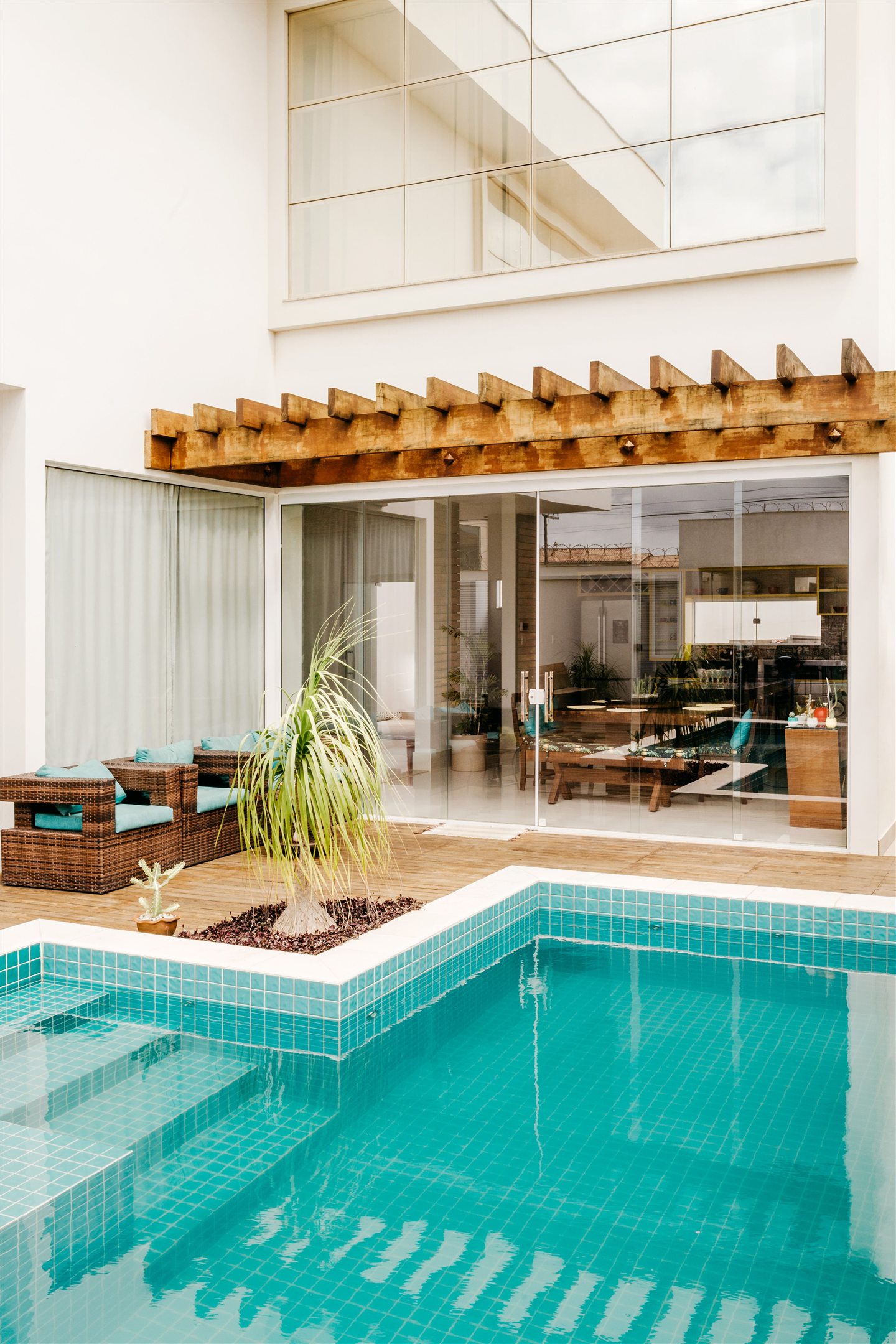 Piscine au pied d’une terrasse couverte et vitrée