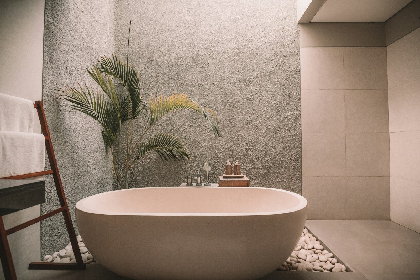 Freestanding bathtub in front of a textured wall