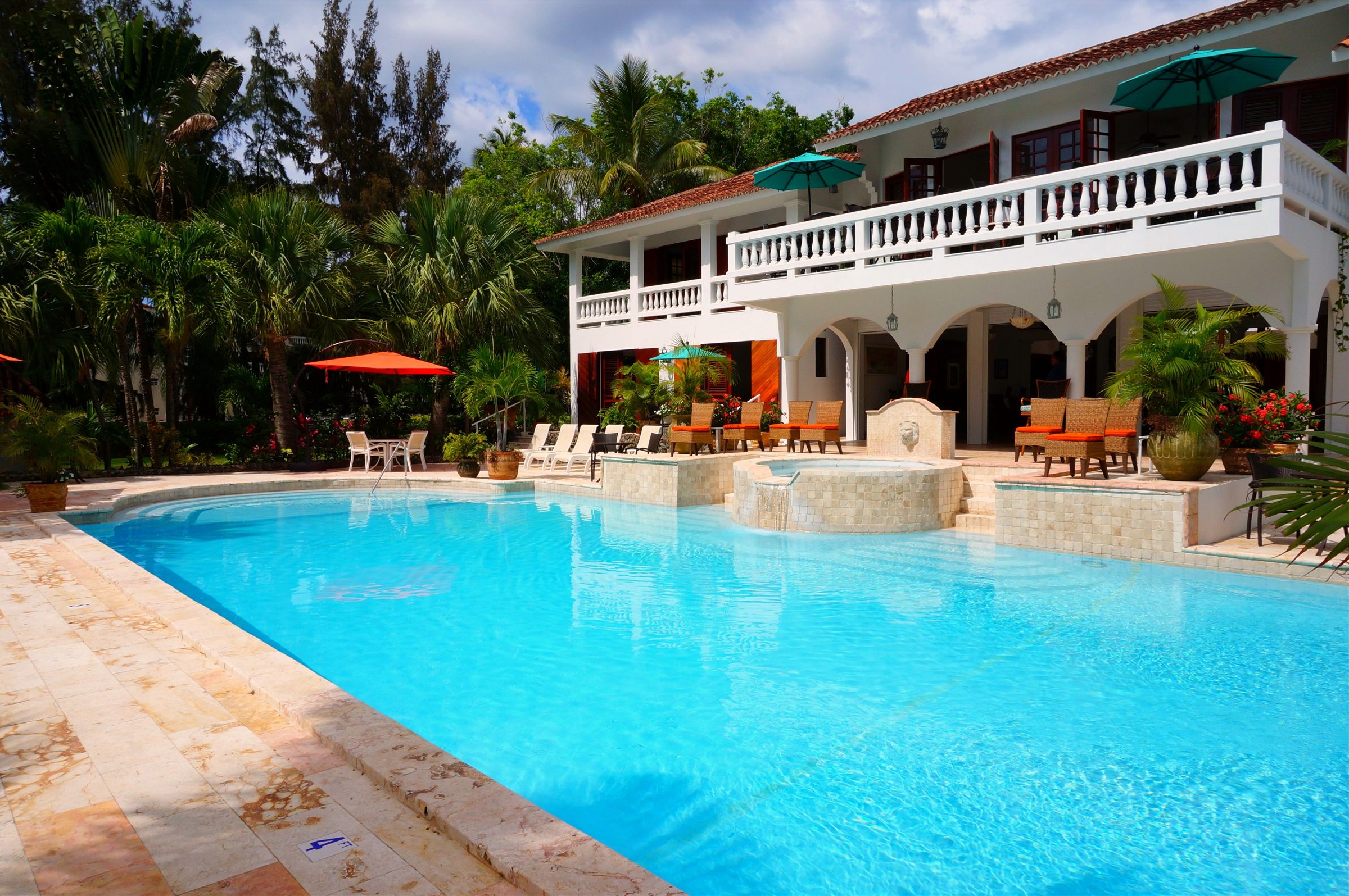 Grande piscine creusée devant une maison avec balcons